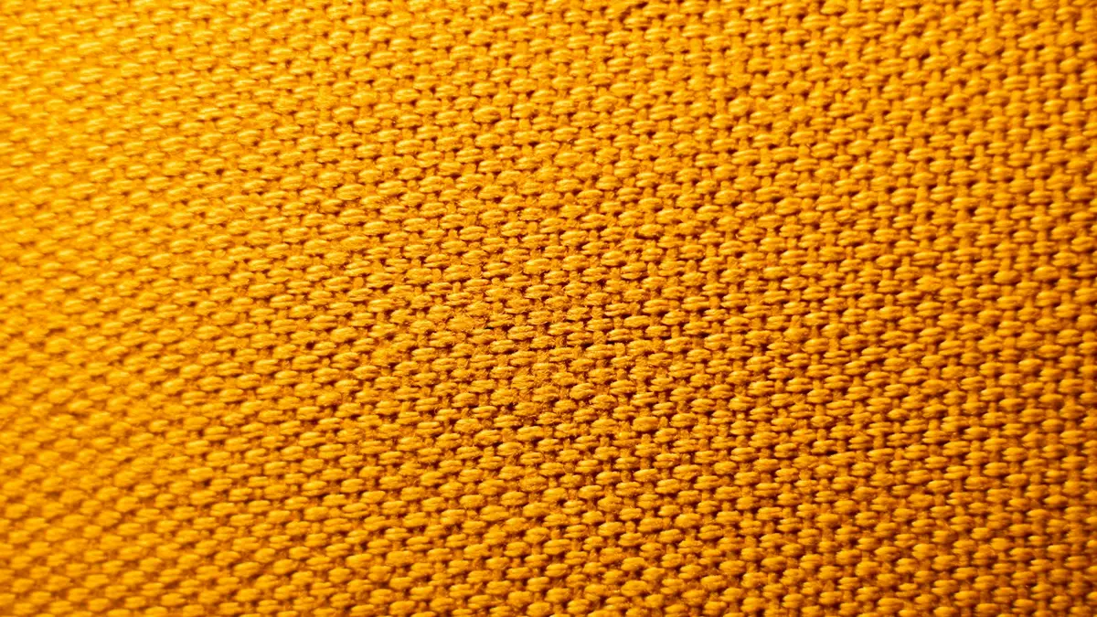 Close-up of a textured yellow fabric showcasing its surface structure and weave.