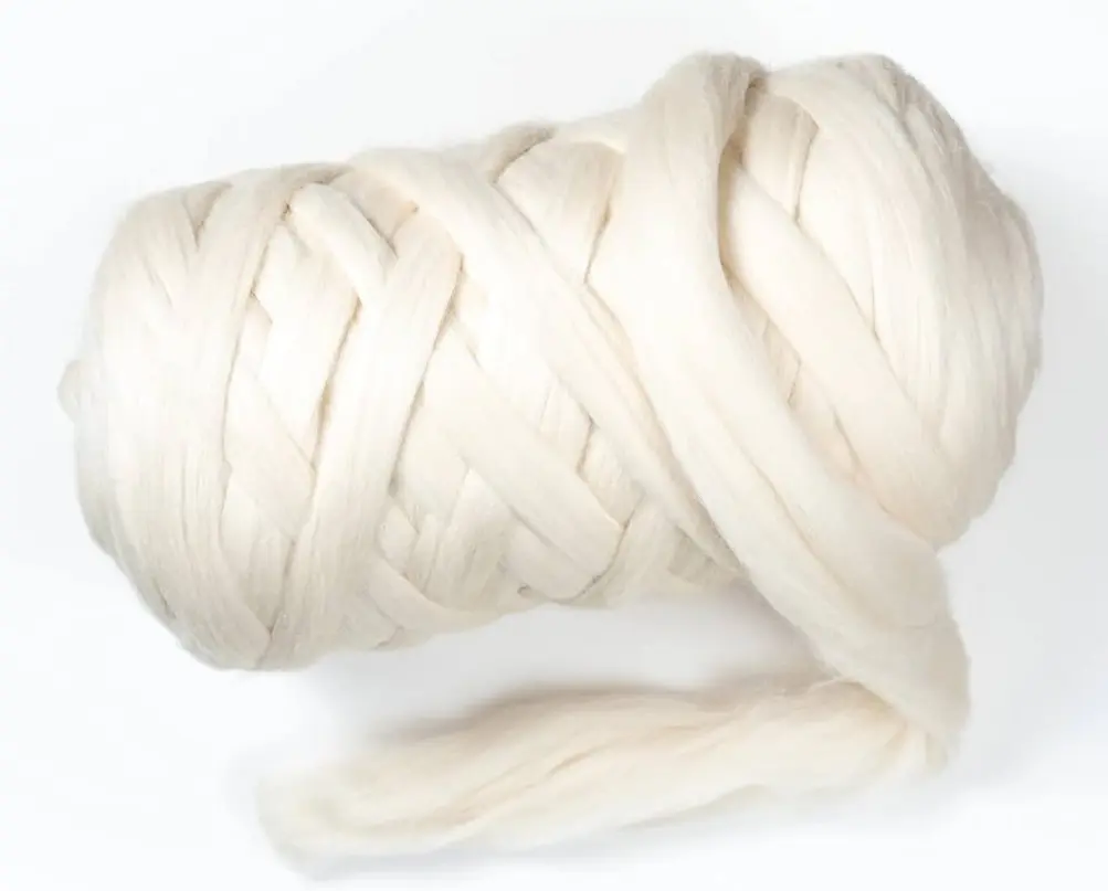 Off-white wool roving loosely wound into a thick bundle, with a soft strand extending below.