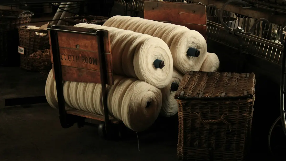 Baskets filled with large spools of thread in a dimly lit industrial setting.